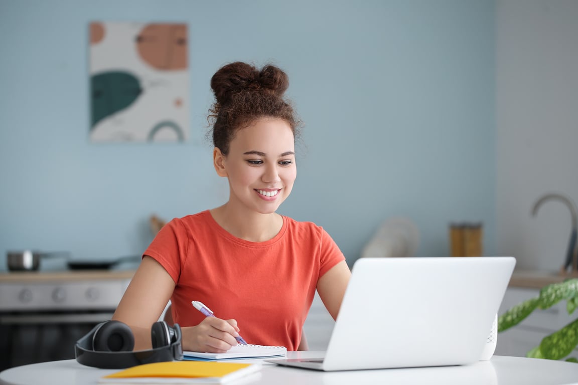 Woman Using Laptop for Online Learning at Home